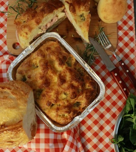 About Us Freshly baked bread and rolls on a checkered tablecloth, perfect for a picnic.